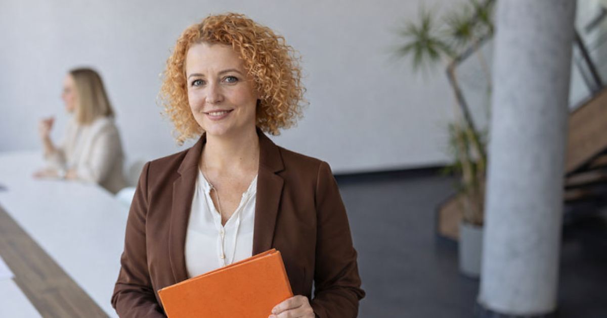 HR and outplacement managers reviewing AI-generated employee transition dashboards and re-employment progress reports on a laptop in a corporate office setting.
